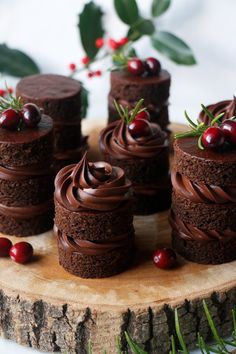 chocolate cupcakes with frosting and cranberries on a wooden platter