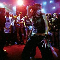 a group of people standing in front of a stage with one person on the dance floor