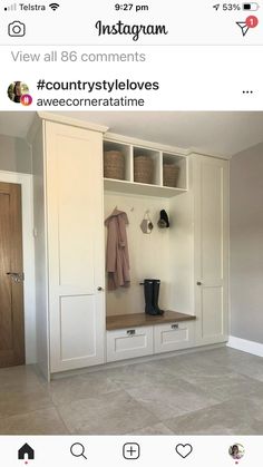 a white closet with some clothes hanging on the wall and other items sitting on top of it