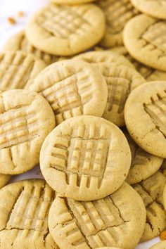 a pile of peanut butter cookies sitting on top of a white tablecloth next to each other