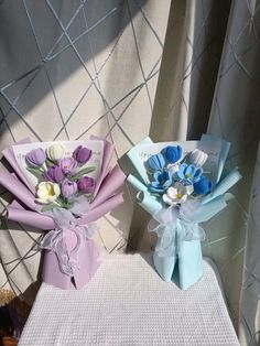 two bouquets of flowers sitting on top of a table