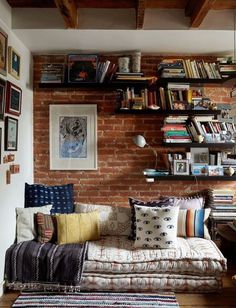 a living room filled with furniture and bookshelves next to a wall covered in pictures