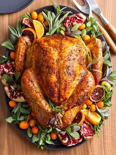 a turkey on a platter with oranges and cranberries