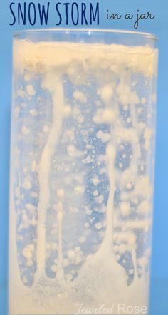 a glass filled with ice and water on top of a blue background that says, how to make snow storm in a jar