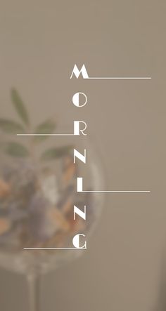 the word morning is written on top of a glass vase filled with flowers and leaves