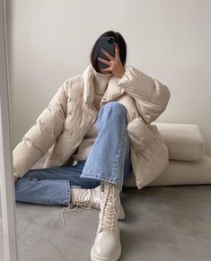 a woman sitting on the floor with her hand up to her face