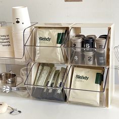 an organized kitchen counter with coffee cups and utensils