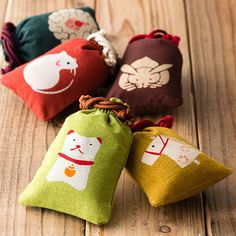 three small pouch bags sitting on top of a wooden table