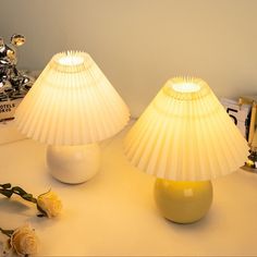 two white lamps sitting on top of a table