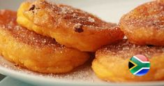 some sugared doughnuts on a plate with a south african flag sticker