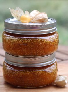 three jars filled with food sitting on top of a wooden table