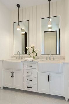 a bathroom with two sinks and three mirrors