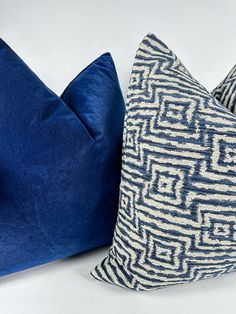 two blue pillows sitting next to each other