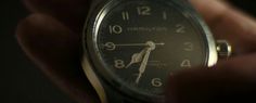 a close up of a person's wrist with a watch in the dark background