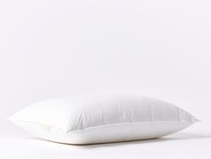 a white pillow sitting on top of a white floor