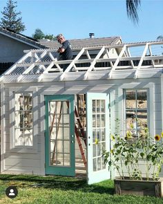 a man standing on the roof of a small house