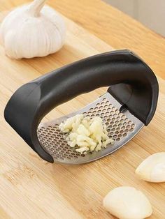 an onion grater on a cutting board next to garlic