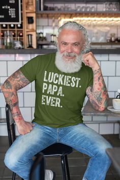 "Men's Papa T Shirt Luckiest Papa Shirts St. Patrick's Day TShirt Father's Day Gift Idea Tee family Shirts Let your dad or papa show off his how lucky he is in this father's day gift idea tee. The design reads 'Luckiest. Papa. Ever.' in a gunge inspired distressed font. This papa t shirt is one he'll be proud to wear all year long and is perfect for St. Patrick's day. Printed on super soft, ring spun cotton. Includes our signature satin lined drawstring gift bag. Our model is wearing military green. REAR PRINT ADD-ON If you would like to add a name and number to the back of this shirt, purchase this listing as well: https://www.etsy.com/listing/1292480103 TERMS FOR PERSONALIZED ITEMS: A proof will be provided to you so that you are afforded the opportunity to review how the item will look Father's Day Family Text Print T-shirt, Father's Day Family T-shirt With Text Print, Father's Day Text Print T-shirt, Father's Day Family Matching T-shirt With Funny Text, Father's Day T-shirt With Funny Text, Father's Day Green Graphic Print Shirt, Father's Day Crew Neck Top With Funny Print, Father's Day Funny Print Crew Neck Top, Green Father's Day T-shirt With Letter Print