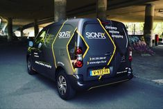 a small van parked under an overpass with graffiti on it's sides and the back