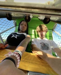 two people sitting in a green chair with their hands on each other's legs