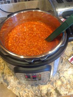 a pot full of red beans sitting on top of a counter next to an electric pressure cooker