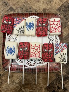 spiderman cake pops on a red and white plate