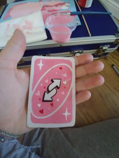 a person holding up a pink playing card