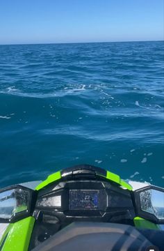 the back end of a green and black jet ski in the middle of the ocean