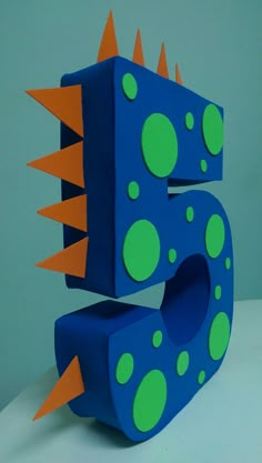 the number five is made out of paper and has spikes on it's head