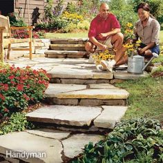 two people are sitting on some steps in the yard