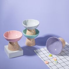 three ceramic bowls sitting on top of a tiled floor next to each other in front of a purple wall