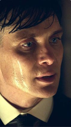 a close up of a person wearing a suit and tie with water on his face