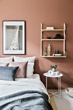 a bedroom with pink walls and white bedding