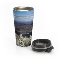 a travel mug with a landscape photo on the front and side, next to it is an insulated lid