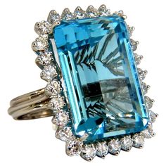 The Aquamarine Blues. GIA Certified 33.85ct. Natural Aquamarine Ring Excellent clean clarity Octagonal Step cut (emerald cut). Vivid Blue Aqua color. Brilliant sparkles from all angles Pristine Transparency Report: 2175101369 1.50ct side diamonds Vs-2 Clarity, G-color Rounds Brilliants full cuts. 14kt. white gold 14.9 grams. Deck of ring: 1.1 X .85 Inch. depth of ring: .52 inch current ring size: 7.75 can be resized (complimentary) $42,000 appraisal certificate will accompany & GIA Report. Topaz Cocktail Ring, Aquamarine Cocktail Ring, Estate Jewelry Rings, Contemporary Engagement Rings, Jewels Rings, Aquamarine Jewelry, Diamonds Ring, Large Gift, Aquamarine Blue