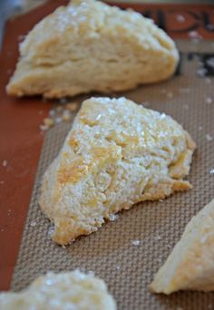 some type of pastry sitting on top of a piece of wax paper with other pastries in the background