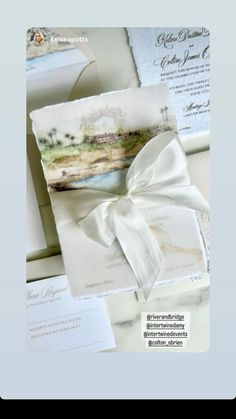 the wedding stationery is laid out on top of each other and tied with a white ribbon