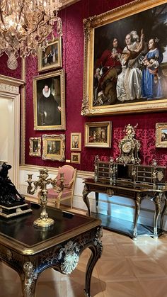 a room with red walls and paintings on the wall