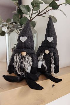 two black gnomes sitting on top of a wooden shelf