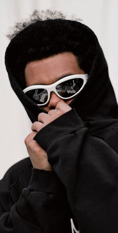 a man wearing sunglasses and a black hoodie