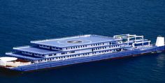 a large blue and white boat floating on top of the ocean next to a dock