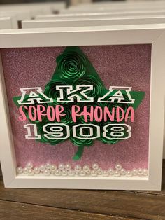 a white frame with a pink and green pinwheel in it that says tarara stop phonona 1908