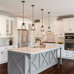 a kitchen with white cabinets and an island