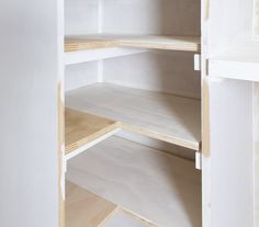 an empty white pantry with wooden shelves