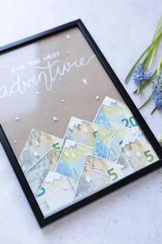 there is a picture frame with the words adventure on it and flowers next to it