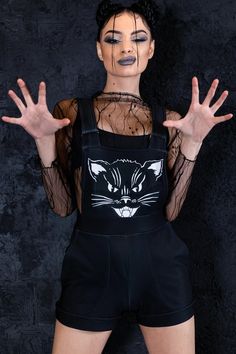 "Black kitty shortalls cuz you are evil and cute. It is soft and warm as your cat and baddy as its soul. The short overalls have side pockets and roomy construction for a comfy fit day and night. ► Material & Washing It's soft, warm, and stretchy. It consists of 80% Polyester, 20% Elastane & feels like Cotton. > Give it a try, and you won't want to take it off. ► Colors The fabric dyes are remarkably vivid, so I must warn you that you will stand out in the crowd! There is no fading or fabric pat Punk Overalls, Black Short Overalls, Dungarees Women, Oversized Overalls, Dungaree Shorts, Womens Overalls, Overalls For Women, Goth Outfit, Black Kitty