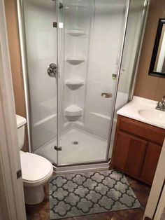 a bathroom with a walk in shower next to a toilet