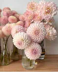 several vases filled with pink flowers on a table