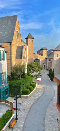 a cobblestone street lined with houses and trees