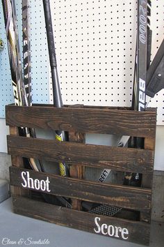 a wooden crate filled with lots of baseball bats next to a sign that says shoot score